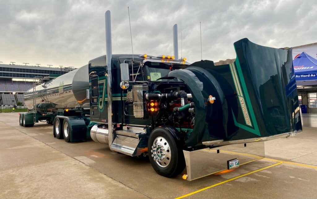 Picture of Jade Transport truck hauling a tanker trailer and hood opened to display the engine.