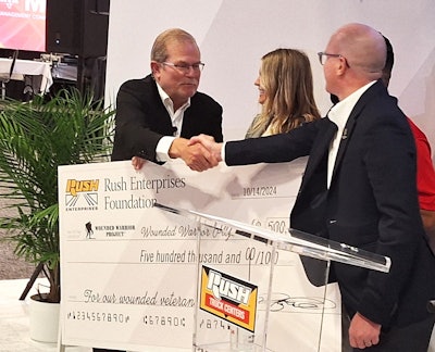 Rush Enterprises CEO Rusty Rush (left) presented the half-a-million-dollar check to Carzoli, shaking the hand of Tommy Upson, marketing VP for Wounded Warrior Project. 'We'll get you a smaller one,' Rush quipped in the aftermath of the check presentation.